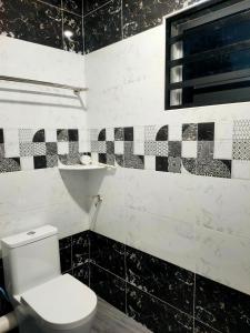 Bagan SeraiChakra Homestay的浴室设有卫生间,铺有黑白瓷砖。