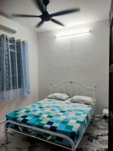 Bagan SeraiChakra Homestay的一间卧室配有一张带吊扇的床