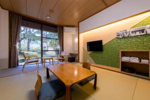 伊势市森之森住宿加早餐旅馆的客厅设有桌子和绿色的墙壁