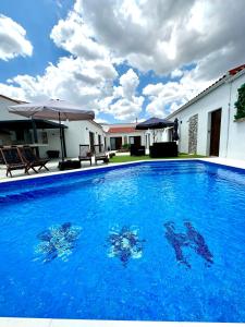 ValdesalorAlojamiento El Miajon de los Castúos的一座大蓝色游泳池,位于房子前