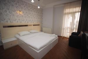 科布列季Hotel Irise的卧室配有一张白色大床和一把椅子