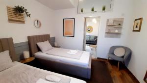 别洛瓦尔Apartment Eleco的小房间设有两张床和椅子