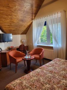 帕兰加Vila Florena的酒店客房带两张床和一张桌子以及椅子。