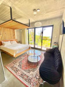 名户Stäy Hotel的一间卧室配有一张床、一张沙发和一张玻璃桌