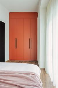 约阿尼纳HOME OF THE SOUL的卧室配有红色橱柜和白色床。