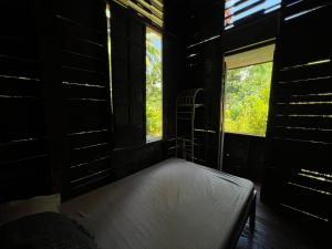 邦劳Peaceland Hostel的一间带床的卧室,位于带窗户的房间内