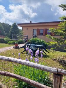 ValgianoChalet Grazia的房屋前方的紫色花 ⁇ 