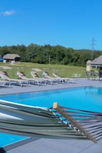 滨湖科伊查赫Keutschacherhof的游泳池,有一堆空椅子