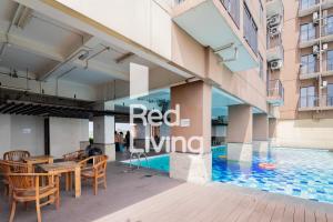 万隆RedLiving Apartemen Tamansari Panoramic - Anwar Rental的一座带游泳池和桌椅的建筑