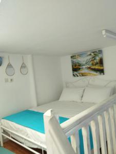 Péran TriovasálosMari...Milo的一间白色卧室,配有一张床和一张婴儿床