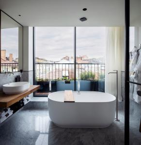 索非亚Juno Hotel Sofia, a Member of Design Hotels的大型浴室设有两个盥洗盆和浴缸。