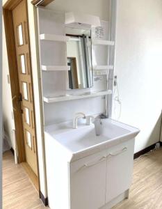 上富良野町メゾンドヴィラ的浴室设有白色水槽和镜子