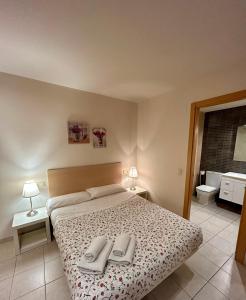 滨海托萨TDM公寓的一间卧室配有一张床,上面有两条毛巾