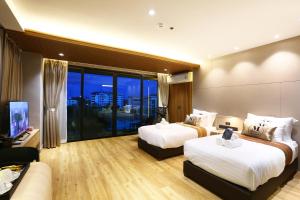 宋卡Montana Hotel Songkhla的酒店客房,设有两张床和一张沙发