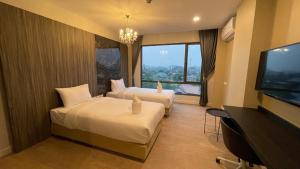 南邦Sibtis Hotel的酒店客房设有两张床和一台平面电视。