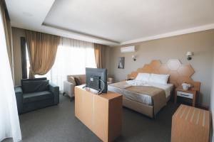 锡利夫凯PALMİLA BUTİK OTEL的一间酒店客房,配有一张床和一台电视