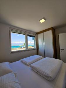 宁Apartmani Adria的卧室设有两张床,享有海滩美景