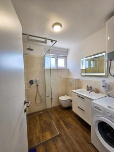宁Apartmani Adria的带淋浴、卫生间和盥洗盆的浴室