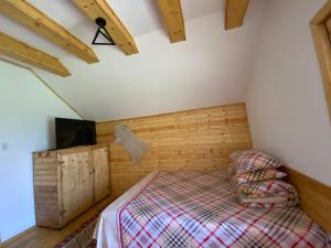 TeşilaCăsuțele Doftanei的卧室配有一张床铺,位于带木墙的房间内