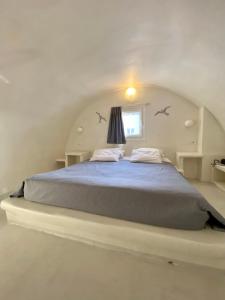 弗通The Muses of Santorini Private Jacuzzi Suites的阁楼上的卧室配有一张大床