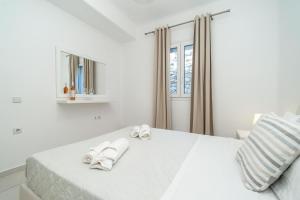 米克诺斯城Overview Mykonos Apartments的白色卧室,床上配有白色毛巾