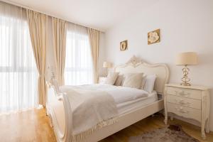 圣沃尔夫冈Pfamhaus Penthouse的白色的卧室设有白色的床和窗户。