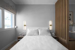 塞萨洛尼基Nephele, The Luxury Suites的白色卧室配有一张带白色枕头的大床