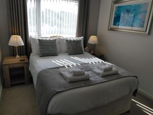 托基Barclay Court Guest House的一间卧室配有一张大床和两条毛巾