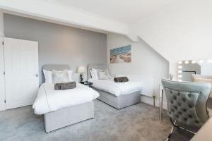 莱瑟姆-圣安妮Birkby Lodge Escape的一间卧室配有两张床和椅子