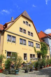 罗滕堡加斯特霍夫布茨酒店的一座黄色的建筑,前面有植物