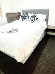 哈罗Flat in London- Modern 2 Bedroom Apartment Harrow near Wembley的一张配有白色床单和枕头的大床