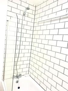 哈罗Flat in London- Modern 2 Bedroom Apartment Harrow near Wembley的带淋浴的浴室和白色瓷砖墙