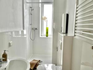 汉诺威Design Apartment - Parking - Kingsize-Bett - 2x Bad - Zentrum的带淋浴和盥洗盆的白色浴室