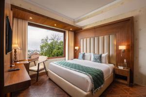 斯利那加WelcomHeritage Grand, Srinagar的一间卧室设有一张大床和一个窗户。