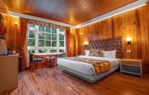 拉亨Summit Gangchen Hotel的一间卧室配有一张床、一张书桌和一个窗户。