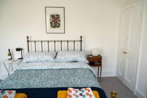 拉姆斯盖特Stylish two bedroom terrace with garden的卧室配有一张床,墙上挂着一幅画