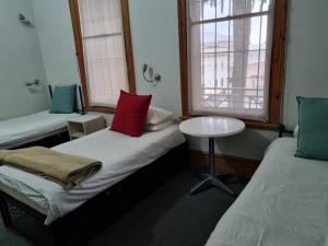 开普敦Ashanti Lodge Backpackers的客房设有两张床、一张桌子和一扇窗户。