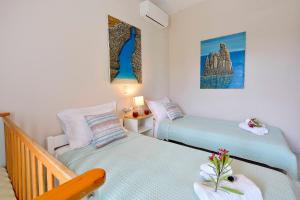 斯达林Ariadni Sidari Beach House的一间小卧室,配有两张床和一张桌子