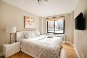 纽约3 BR in Upper West Side的白色的卧室设有床和窗户