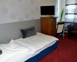 翁纳纳克特瓦斯特尔酒店的一间卧室配有一张床和一台平面电视