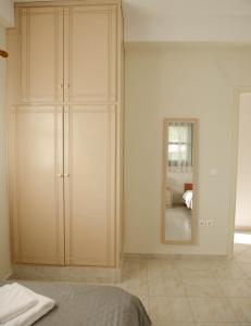 AnomeriáPerfetto Country House - Myrtos View的一间卧室设有大柜子和镜子