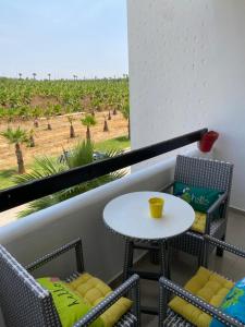 艾西拉lovely and chic Appartment in asilah marina golf的阳台配有桌椅,享有田野美景。
