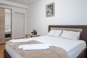 赫尔采格诺维Apartments Maxi Katić的一间卧室配有一张大床和两条毛巾