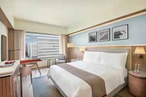 孟买纳瑞曼区三叉酒店 的酒店客房设有一张大床和一张书桌。