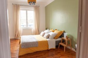 布雷斯特Appartement spacieux avec balcon et parking的一间卧室配有一张带黄色床单的床和一扇窗户。