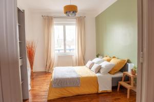 布雷斯特Appartement spacieux avec balcon et parking的一间卧室配有一张带黄色床单的床和一扇窗户。