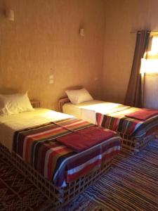 锡瓦Aghurmi Siwa Ecolodge & Salt Cave的酒店客房的两张床