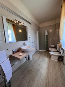 萨罗Hotel Conca d'Oro的大型浴室设有两个水槽和两个卫生间