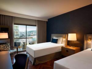 里约热内卢Fairmont Rio de Janeiro Copacabana的酒店客房设有两张床和窗户。