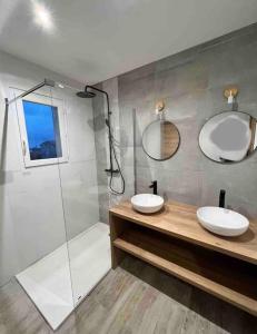 卡伦扎纳Belle villa neuve avec jardin et parking的一间带两个盥洗盆和淋浴的浴室